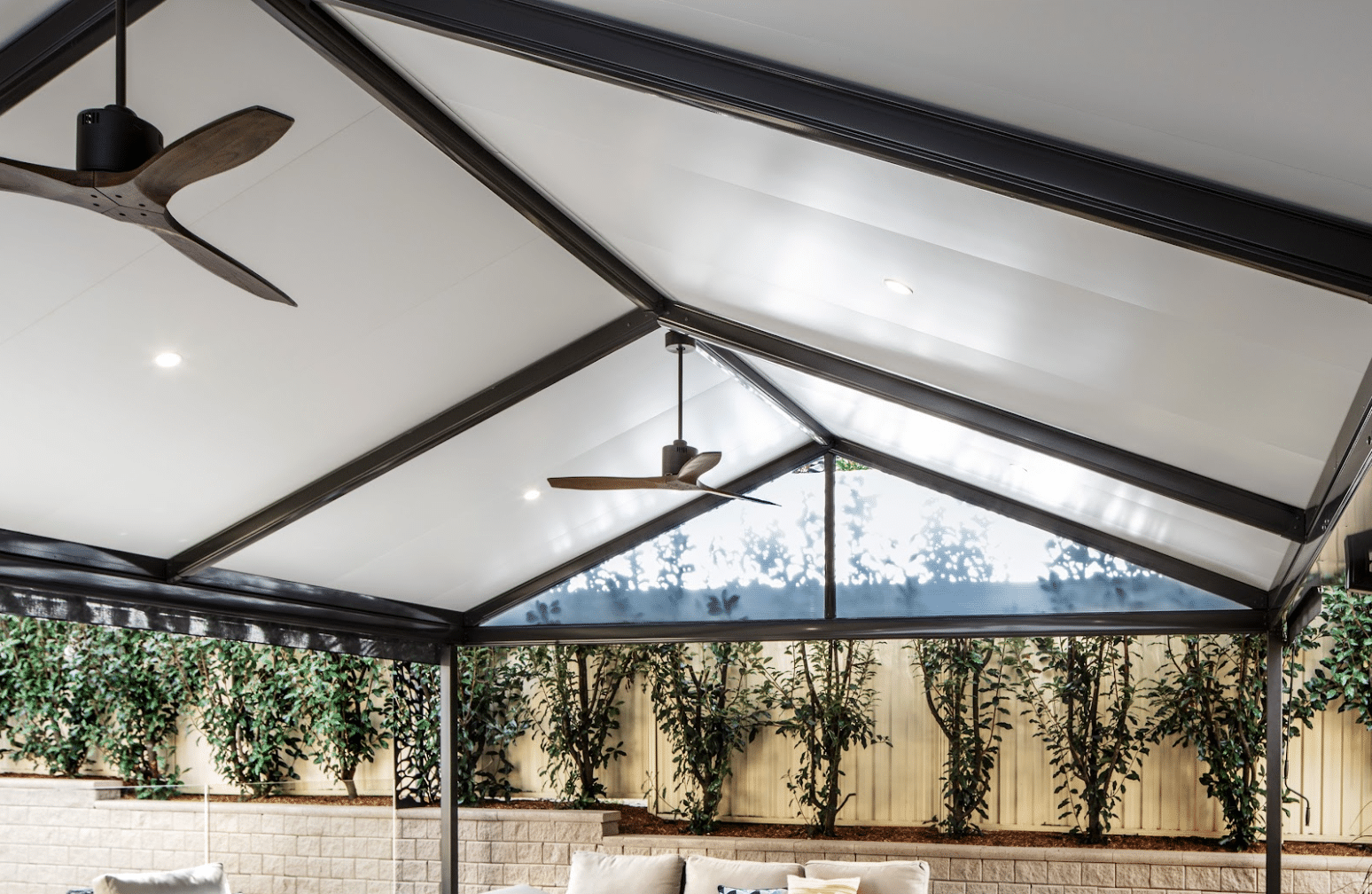 MyLiving Outdoors steel verandah with outdoor fans and a block retaining garden wall